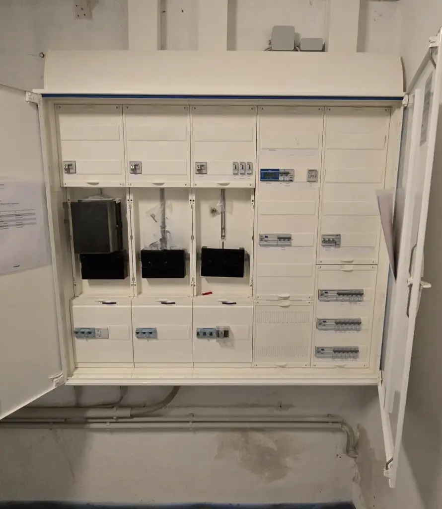 Geöffneter Zählerschrank mit mehreren Zählerplätzen und Sicherungsautomaten